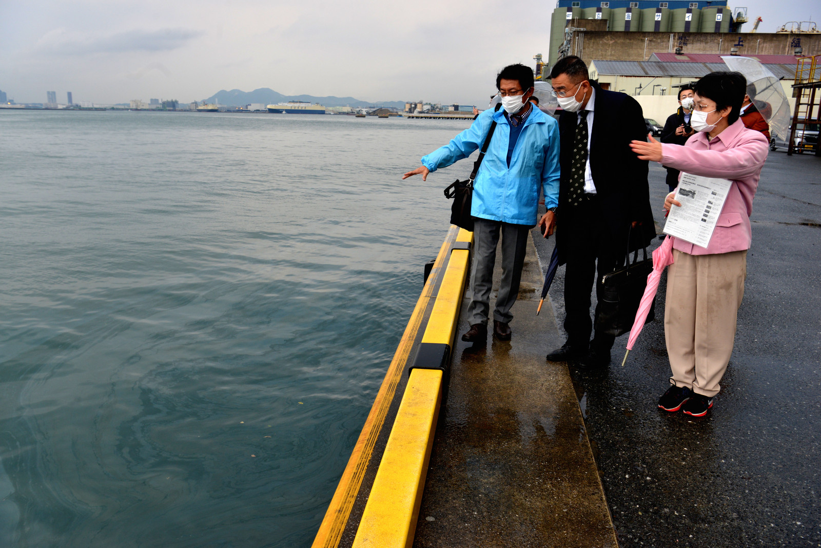 博多港の岸壁に流れ着いた油を調査する田村氏（左）と党福岡市議団のメンバー＝３日、福岡市中央区