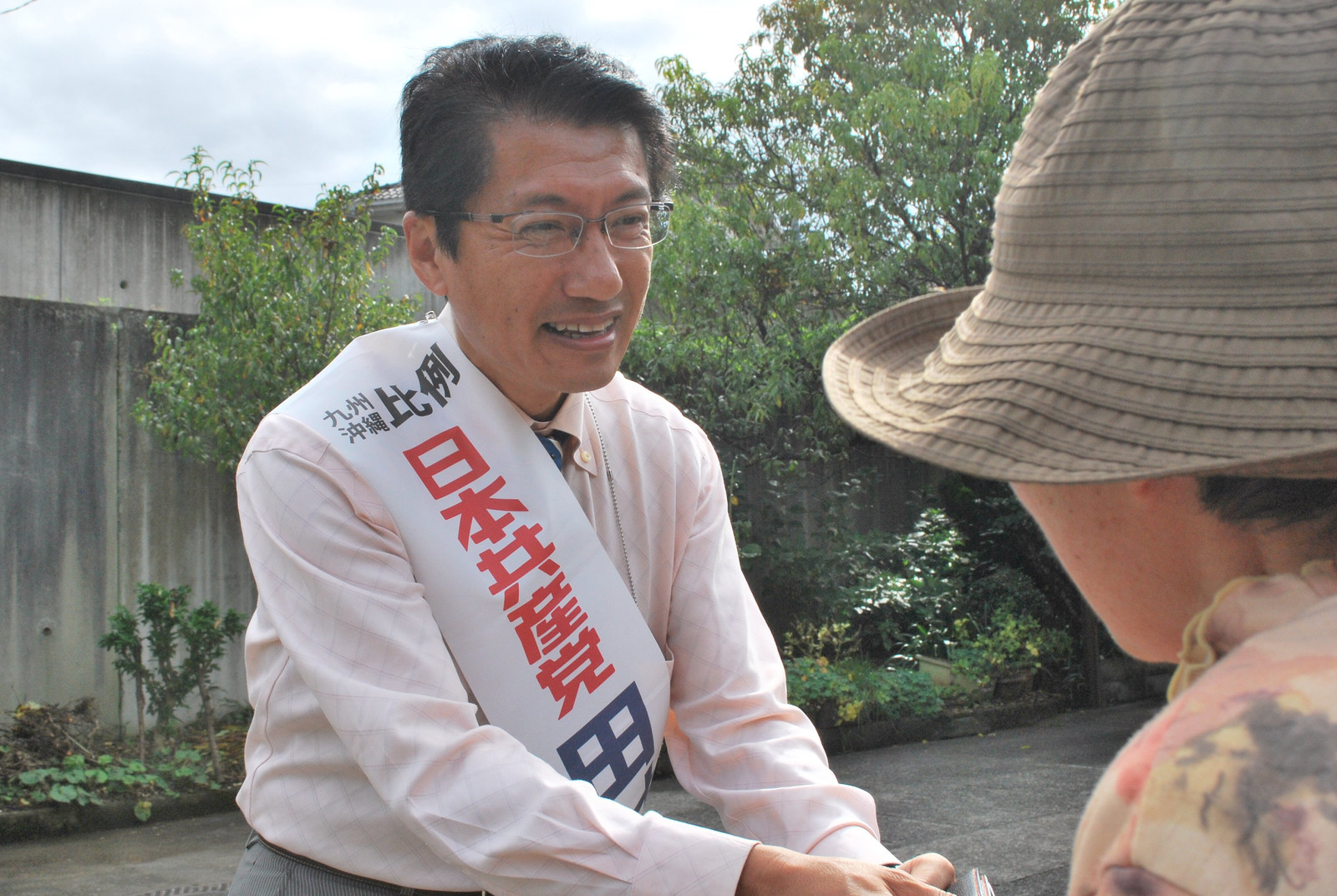 街角で市民の声援に応える田村候補＝13日、大分県日田市