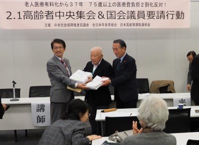 日本共産党の田村衆院議員（左）に７５歳以上の医療費窓口負担２割化反対の署名を手渡す金子、住江の両氏＝３１日、衆院第１議員会館