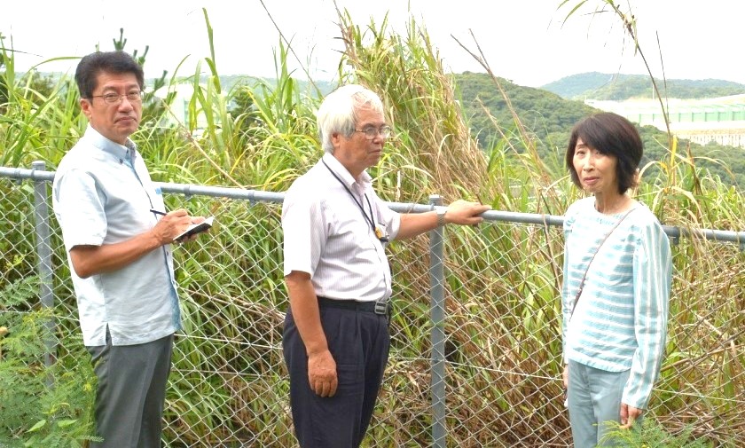 射撃場（右奥）など奄美駐屯地を調査ずる（左から）田村、サキダ、まつざき各氏＝24日、鹿児島県奄美市