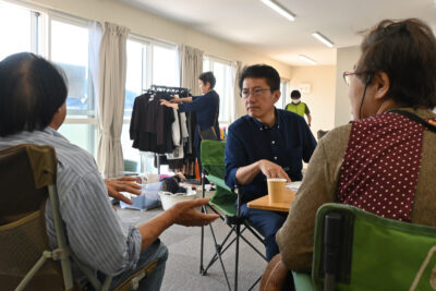 仮設住宅の敷地内にある集会所で、被災者から話を聞く田村貴昭氏（正面）＝１日、石川県輪島市