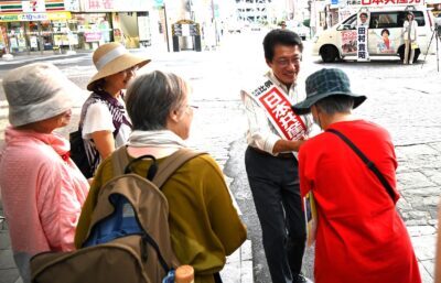 演説を聞いた聴衆の応援に応じ握手を交わす田村候補＝16日、熊本市