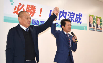 励ますつどいで声援に応える（左から）山内、田村両氏＝８日、北九州市若松区