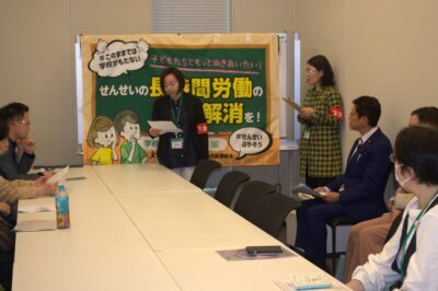 あいさつする全教の金井裕子書記長（中央）＝２３日、国会内