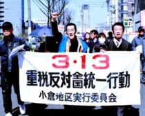参加者とともにデモ行進する田村氏（前列右端）＝１１日、北九州市小倉北区