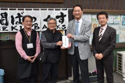 山田（左から２人目）、渡辺（左端）の両氏らに義援金を届ける（右へ）堤、田村の各氏＝３月１８日、大分市佐賀関