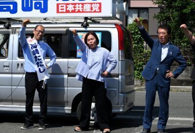 必勝めざし団結頑張ろうを唱和する（右から）田村、東、高崎の各氏＝17日、熊本県菊池市