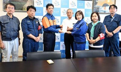 （写真）光井正吾市長（左から３人目）に救援募金を手渡す、（右から）松岡勝県委員長、東なつこ県副委員長・県議予定候補、田村智子委員長、福田けい一市議、（左から）田村貴昭前衆院議員、仁比聡平参院議員＝７日、熊本・宇土市役所
