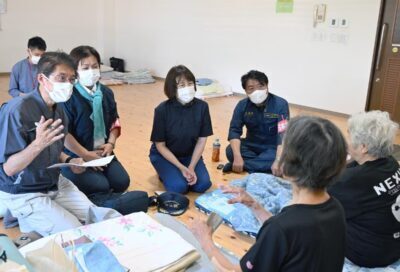 （写真）避難生活を送る人たちから状況を聞く、（奥右から）仁比聡平参院議員、田村智子委員長、東なつこ県副委員長・県議予定候補、田村貴昭前衆院議員＝７日、熊本県宇城市の豊野防災拠点センター